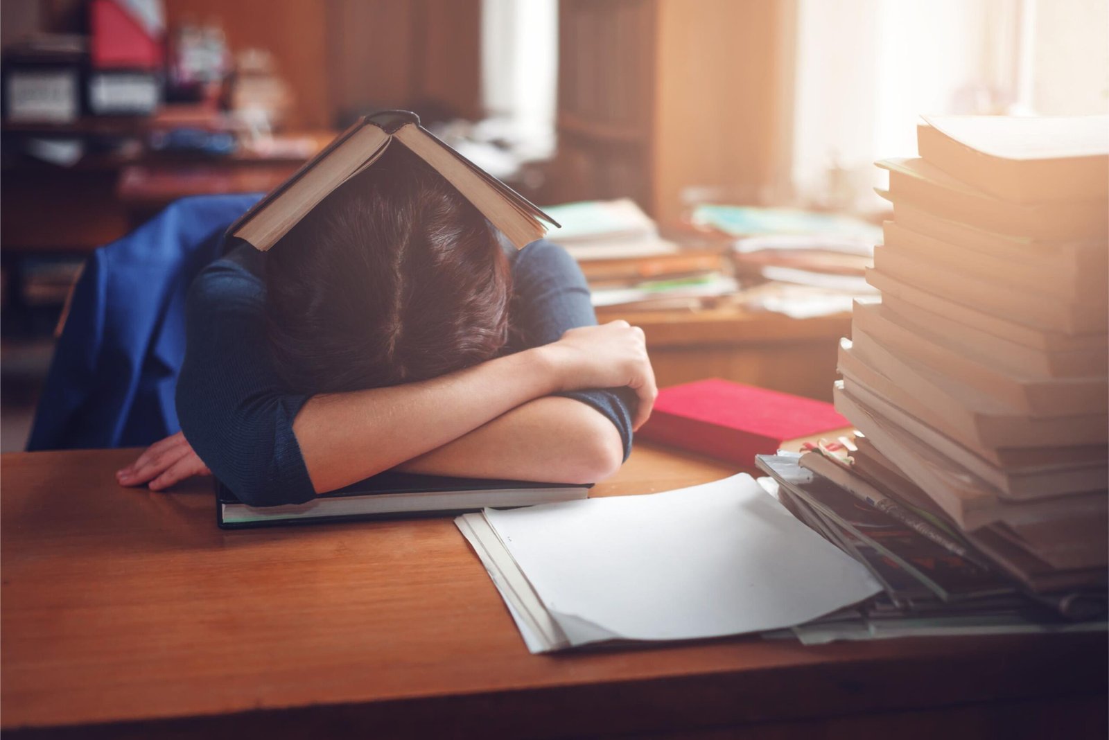 Student overwhelmed by studying materials, representing disengagement in traditional learning